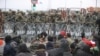 Migrants gather on the Belarusian-Polish border, while Polish military police stand guard on the Polish side of the frontier, at the Bruzgi-Kuznica border crossing on November 15.