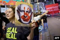 Relatives and supporters of Israelis held hostage by Hamas in Gaza since October 7, 2023, lift placards calling on the United States to intervene for their release, during a demonstration in Tel Aviv on October 22.