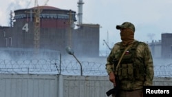  A serviceman with a Russian flag on his uniform stands guard near the Zaporizhzhia nuclear power plant in Ukraine. (file photo)