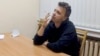 Raman Pratasevich smokes a cigarette while speaking in a video from a detention center in Minsk, broadcast by the state-controlled ONT channel on June 2. "I have noticed handcuff marks on his hands," his mother says. 