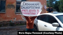 Vera Popova of Ufa, who is a distant relative of a conscript, holds a placard telling recruits that they have no business being sent to areas near the front lines with Ukraine.