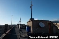 Meko on the rooftop of the house with seven crosses.