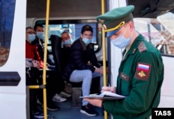 Conscripts board a shuttle bus at a recruitment center in Kalingrad before departing for military service with the Russian Army.