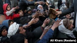 A man distributes bread to needy people in the Afghan capital, Kabul. (file photo)