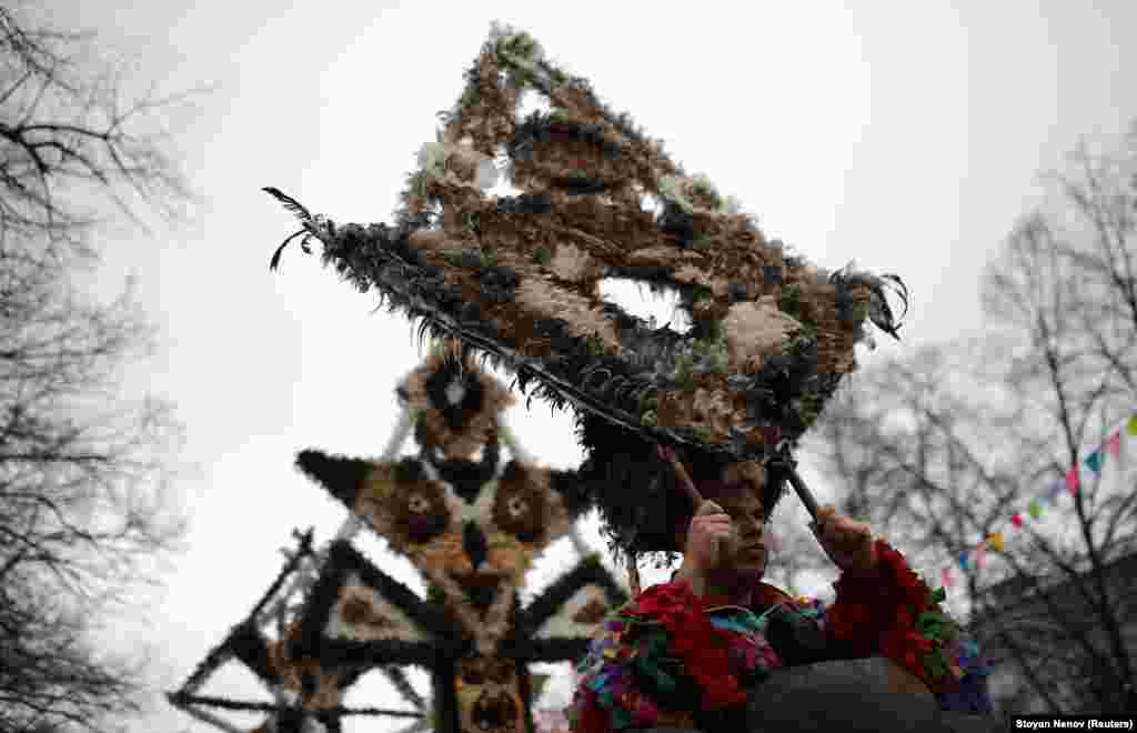 Men hold up masks made of feathers. Since 2008, the festival has been conducted every year during the last Saturday and Sunday of January.