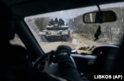 A Ukrainian tank with soldiers is seen through a car window close to the front line near Kremenna in January.