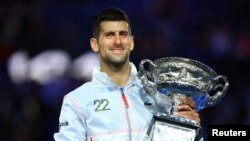 Serbia's Novak Djokovic celebrates with the trophy after winning the Australian Open last month.