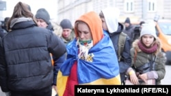 A Ukrainian woman wrapped in a Ukrainian flag arrives with other refugees in Poland in March 2022. The Kremlin has targeted Poland, in particular, with social media disinformation campaigns aimed to stir up public resentment toward refugees. 