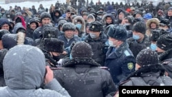 Police talk with demonstrators protesting fuel prices in the western Kazakh city of Oral on January 4. 