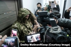 Journalists, lawyers, and supporters rushed to the scene of the raid, finding their way barred by a stern man wearing a green balaclava.