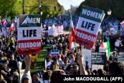 Protesters display placards reading "Women, Life, Freedom" at a rally in support of the demonstrations in Iran following the death of Mahsa Amini, in Berlin on October 22, 2022.