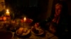 A woman eats dinner by candlelight during a blackout to conserve energy in the Moldovan capital, Chisinau. (file photo)