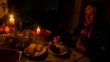 A woman eats dinner by candlelight during a blackout to conserve energy in the Moldovan capital, Chisinau. (file photo)