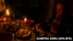 A woman eats dinner by candlelight during a blackout to conserve energy in the Moldovan capital, Chisinau. (file photo)