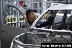 A man works on a car assembly line at the PCMA Rus car plant in Rosva Industrial Park in the Kaluga region.