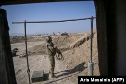 An Armenian soldier looks up toward a drone flying above his position in October 2020.