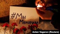 Supporters place candles and flowers at the Solovetsky Stone in St. Petersburg after Russia's Supreme Court ruled that Memorial must be liquidated for breaking the law on foreign agents, on December 28.