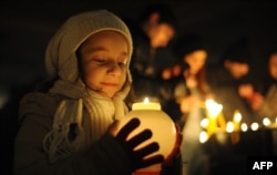 A young girl holds a candle outside St. Gregory the Illuminator Church in Yerevan. (file photo)