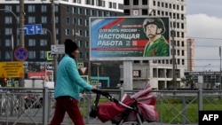 A billboard in St. Petersburg promoting army service with an image of a serviceman and a slogan that says, "Serving Russia is a real job."