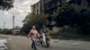 Residents walk past a war-damaged building in the center of the recently liberated town of Izyum in Ukraine's Kharkiv region on September 13. 