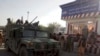 Taliban fighters stand guard at a checkpoint in Kunduz City in northern Afghanistan on August 9.