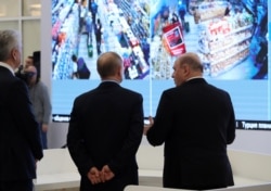 Russian President Vladimir Putin, accompanied by Prime Minister Mikhail Mishustin (right) and Moscow Mayor Sergei Sobyanin (left), tours a new coronavirus information center in Moscow on March 17.