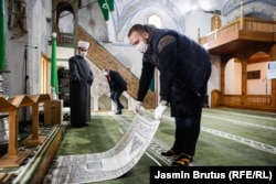 A believer places a prayer rug on the floor of the Cekrekcijina Mosque in Sarajevo, Bosnia-Herzegovina, on May 6. (Jasmin Brutus, RFE/RL)