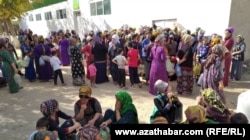 People gather outside a state grocery store in Mary to buy subsidized food.