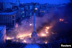 Smoke rises above Independence Square during anti-government protests in central Kyiv in the early hours of February 19, 2014.