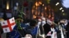 People wave Georgian and EU flags -- and roses -- to mark the anniversary of the Rose Revolution in Tbilisi in 2021.