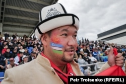 A spectator enjoys the games with face paint diplaying the flags of Kyrgyzstan and Uzbekistan.