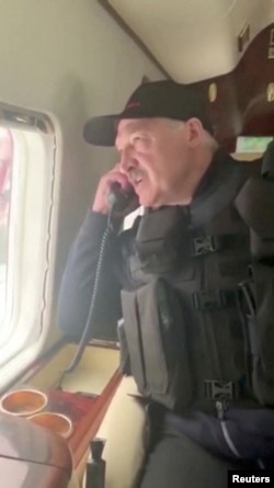 Lukashenka talks on the phone onboard a helicopter during his flight over Minsk on August 23.