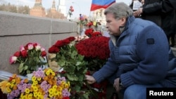 A man lays flowers on the bridge in Moscow where Russian politician Boris Nemtsov was killed.