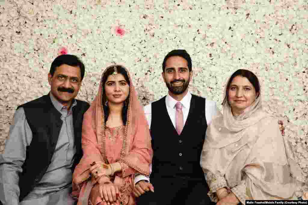 Yousafzai poses with her father, Ziauddin, her husband, Asser Malik (second right), and her mother, Toorpekey, at their home in Birmingham, England, on November 9, 2021.