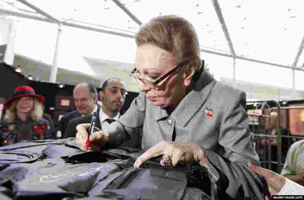 Farah signs an autograph as she visits a contemporary art fair in Monaco in April 2013.&nbsp;