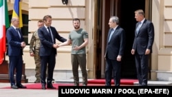 Ukrainian President Volodymyr Zelensky (center) shakes hands with France's President Emmanuel Macron as Germany's Chancellor Olaf Scholz (left), Italy's Prime Minister Mario Draghi (second from right), and Romania's President Klaus Werner Iohannis look on prior to their meeting in Kyiv on June 16. 