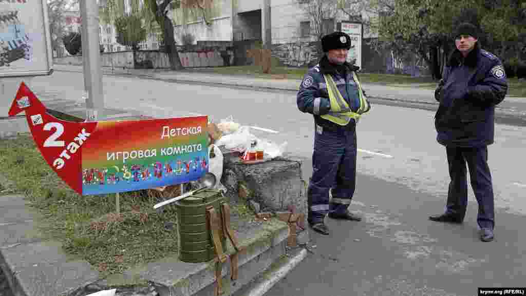 Добросердечные &nbsp;старушки пытаются угостить милиционеров, дежурящих в оцеплении. Те категорически отказываются и перекусывают развозимым интендантскими службами пайком и супом из армейских ранцевых термосов.