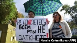 A woman holds a sign reading "You can't shut up everyone!" as journalists and supporters take part in a protest against the list of "foreign agent" media in central Moscow on September 4.