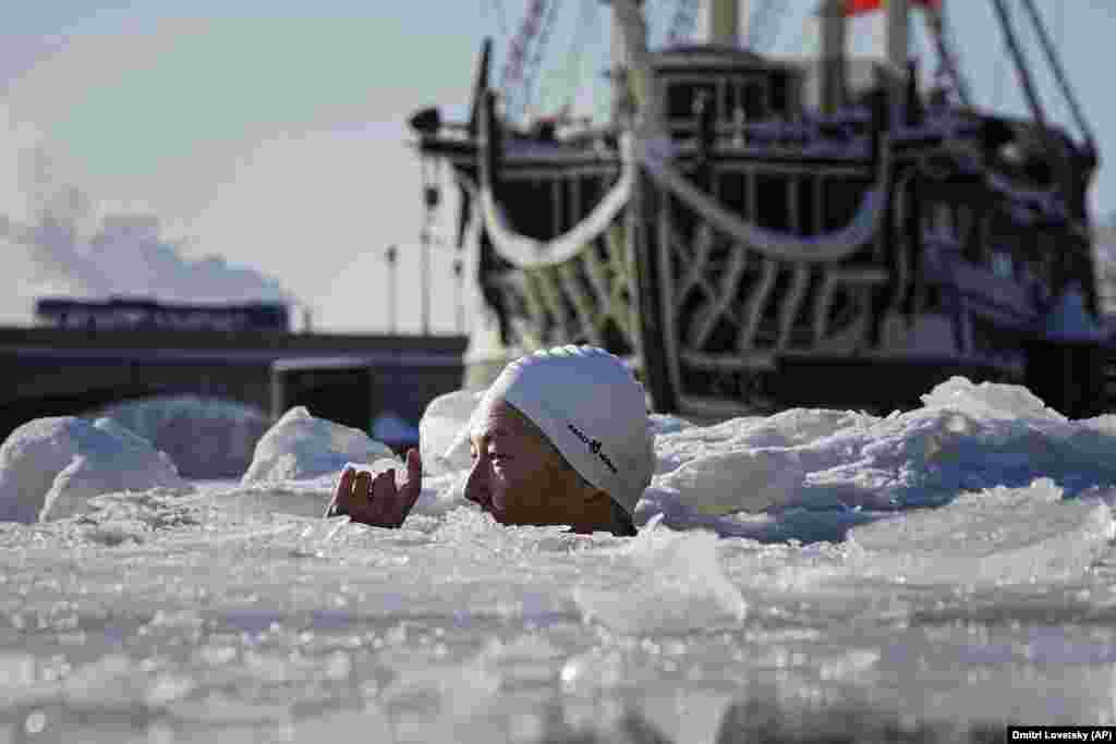 A woman bathes in an ice hole in the Neva River, in St. Petersburg, Russia. 