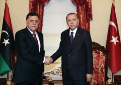 Turkish President Recep Tayyip Erdogan (right) meets with Fayez al-Sarraj, the head of the Tripoli-based Government of National Accord, in Istanbul on December 15.