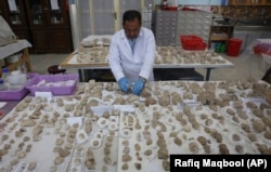 Conservator Sherazuddin Saifi works on pieces of a small statue damaged by the Taliban because they were judged to be against Islam at the National Museum of Afghanistan in Kabul in August 2019.