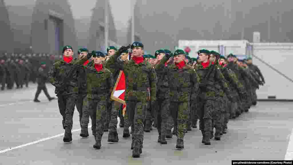 Polish soldiers deployed to guard their country's border with Belarus salute Poland's defense minister, Władysław Kasiniak-Kamys, who paid them a visit on February 26.