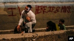 People take cover on the side of a road as a siren sounds a warning of incoming missiles fired from Iran on a freeway in Shoresh, between Jerusalem and Tel Aviv, on October 1.