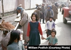 Two sisters pose for a photograph on a street in Kabul.