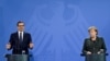 Polish Prime Minister Mateusz Morawiecki (left) and German Chancellor Angela Merkel address a joint press conference after talks in Berlin on November 25.