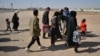 Afghans who were forcibly sent back to their country from Iran walk near the Islam Qala border crossing in the western Afghan province of Herat in October 2021.