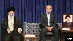 Sitting next to a portrait of late Iranian President Ebrahim Raisi, Masud Pezeshkian attends a ceremony for his presidential endorsement by Supreme Leader Ayatollah Ali Khamenei (left) in Tehran on July 28. 