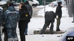 Investigators and police experts work by a body at the blast scene, which killed the commander of Russian armed forces' chemical, biological and radiation defence troops, Igor Kirillov, and his assistant, according to the Russian Investigative Committee,