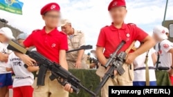 Two boys from Yunarmia hold guns at an event in Sevastopol, on the Russian-occupied Crimean Peninsula, in August 2019.