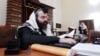 A man swathed in a tallit, or Jewish prayer shawl, reads a religious book at a synagogue in Baku. (file photo)